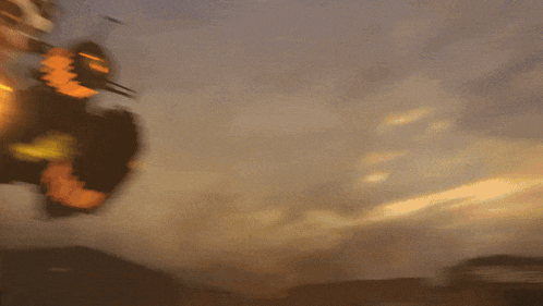 a blurred image of a roller coaster with a sunset in the background