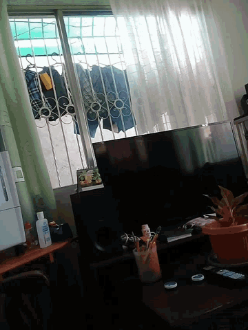 a bottle of aquafina sits on a table next to a television