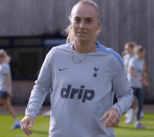 a female soccer player wearing a grey drip shirt