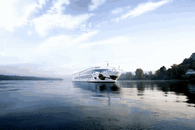 a large white and red cruise ship is floating on a lake