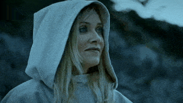 a woman wearing a hooded sweatshirt is looking to the side
