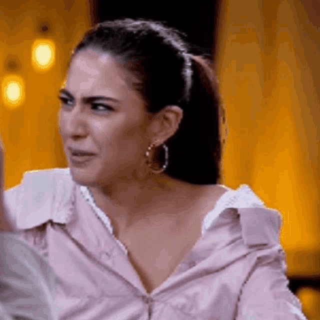 a woman in a pink shirt is making a funny face .