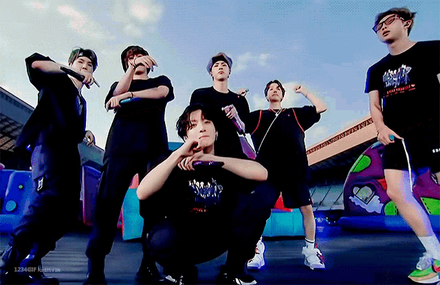 a group of young men are posing for a picture with one wearing a t-shirt that says army on it