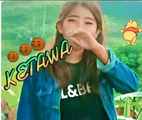 a girl wearing a shirt that says ketawa covering her nose