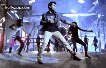 a man is dancing on a stage in front of a group of people .