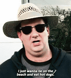 a man wearing a straw hat and sunglasses says i just wanna lie on the beach and eat hot dogs