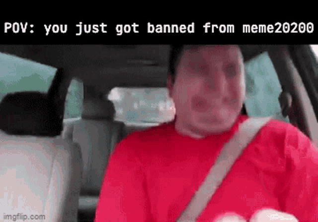 a man in a red shirt is sitting in the back seat of a car with a seat belt on .