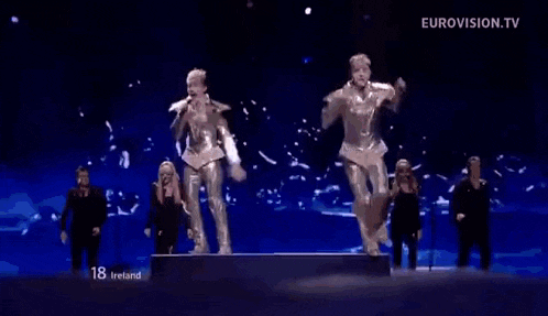 a group of people are dancing on a stage while holding microphones .