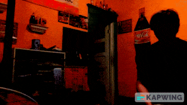 a coca cola bottle hangs on a wall in a room