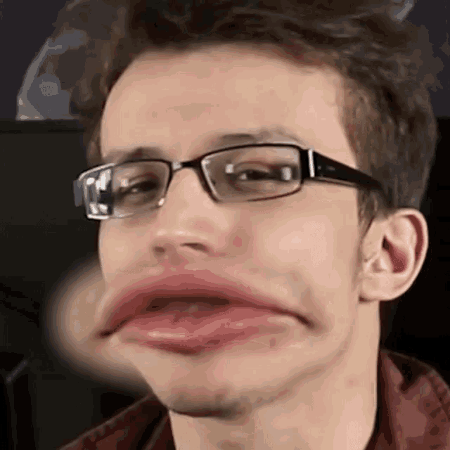 a man wearing glasses is making a funny face with his mouth wide open .