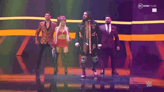 a group of people are standing on a stage in front of a crowd .