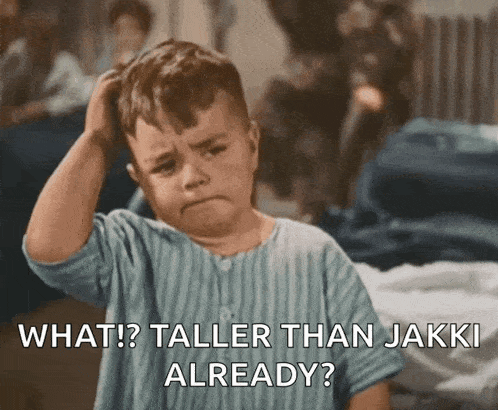 a little boy is scratching his head with the words what ? taller than jakki already