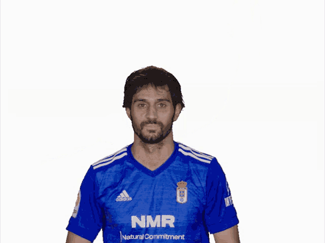 a man wearing a blue nmr shirt covering his eyes