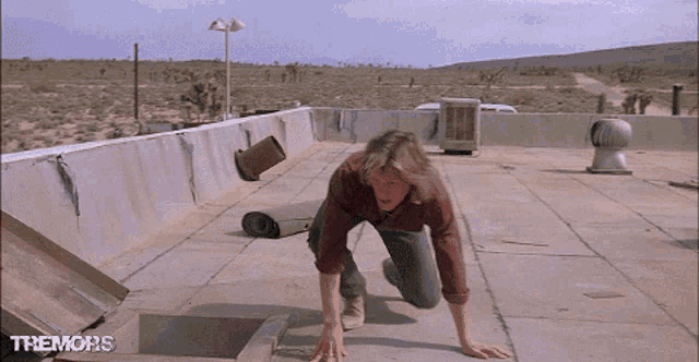 a man is crawling on the roof of a building with the words themons on the bottom right
