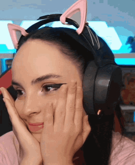 a woman wearing a headset with pink cat ears on her head