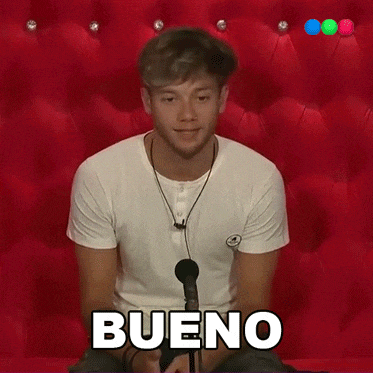 a man sitting in front of a microphone with the word bueno written on his shirt