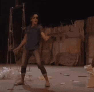 a person in a blue shirt and jeans is dancing