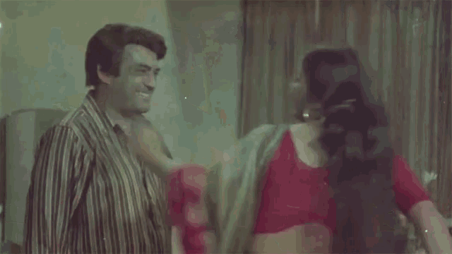 a man and a woman are hugging in a living room .