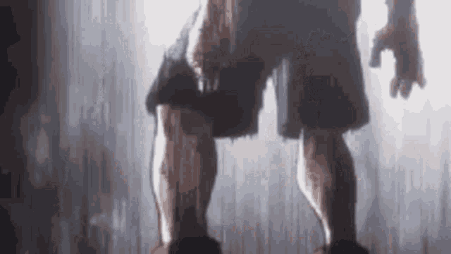 a close up of a person 's legs with blood on them standing in the rain .