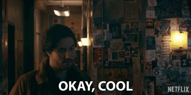 a man says okay cool in front of a wall with stickers