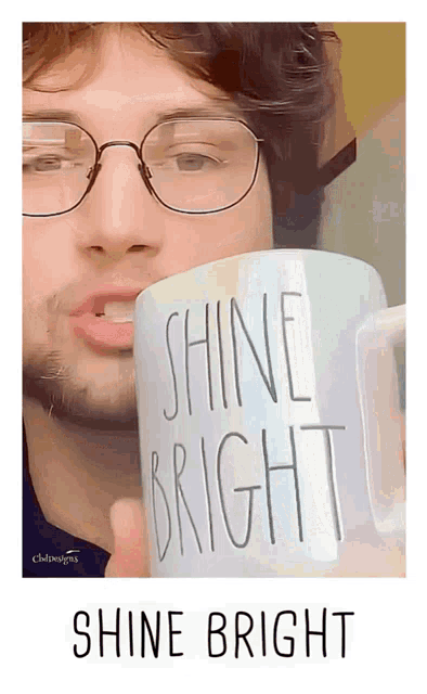 a man is holding a mug that says shine bright