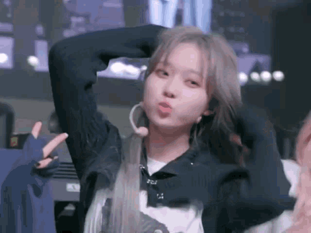 a young woman is making a funny face with her hand in her hair .