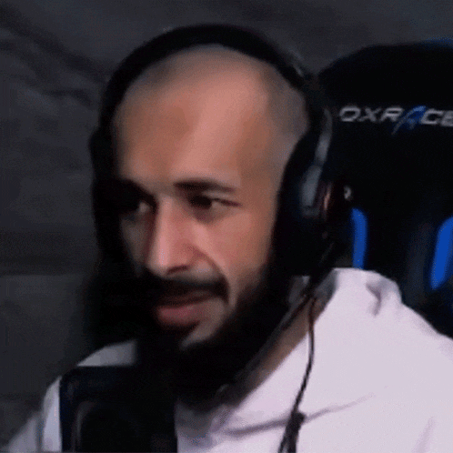 a man with a beard wearing headphones and a microphone .