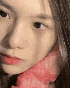a close up of a person 's face with a pink scarf around her neck