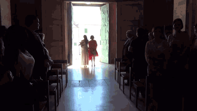 a woman in a red dress stands in front of a church door