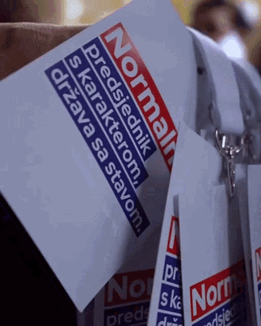 a person holding a card that says normal