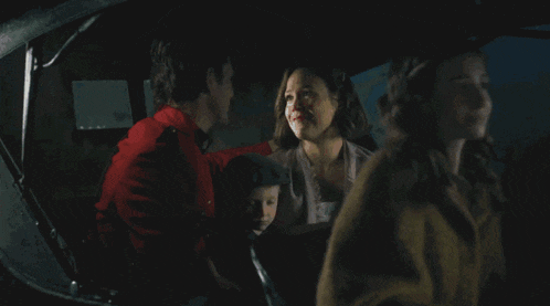 a man and a woman are sitting in a car with a child