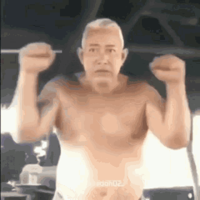 an older man is flexing his muscles in a gym .