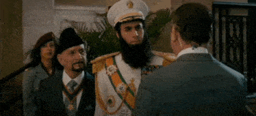 a man with a beard is standing in front of two other men and says you 're .