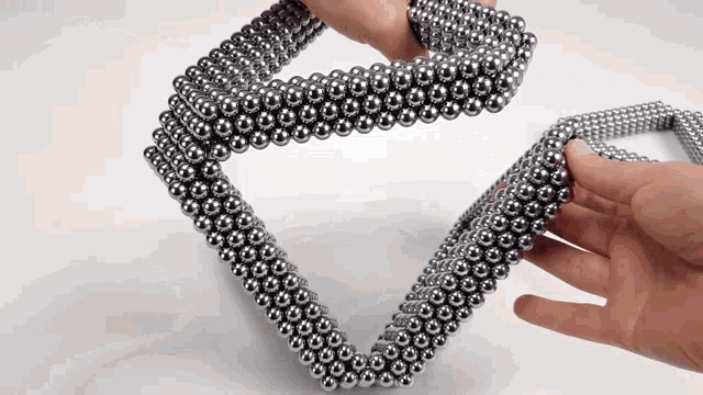 a person is holding a necklace made of balls