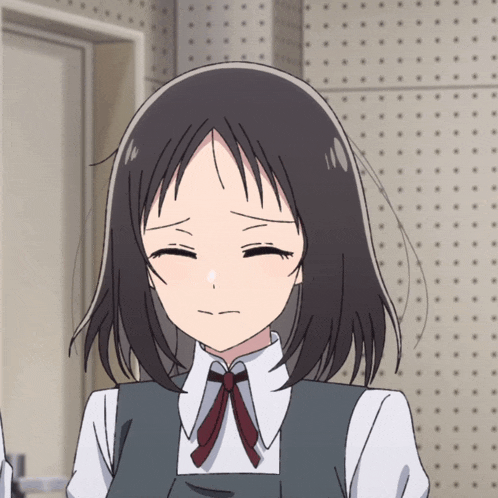 a girl with short black hair and a red bow tie is making a sad face