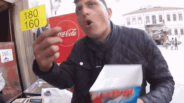 a man in front of a sign that says coca-cola