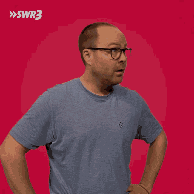 a man wearing glasses and a blue shirt with the letters swr3 on the bottom