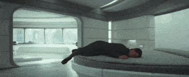 a man is laying on a round bed in a room