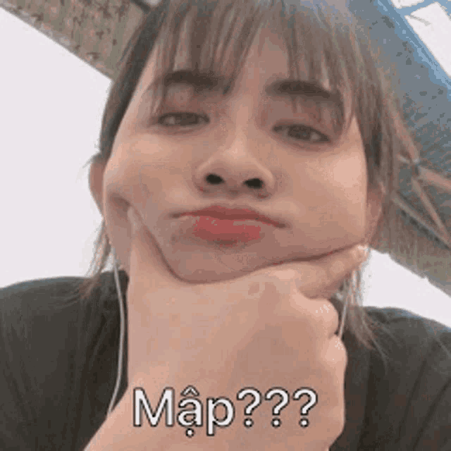 a woman is making a funny face with her hand on her chin and the words map written on her face .