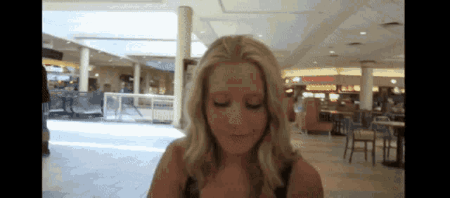 a woman in a mall with a sign that says mcdonald 's in the background