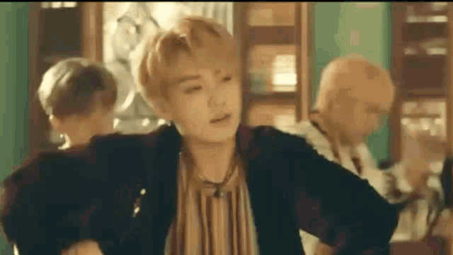 a group of young men are dancing in a room in front of a mirror .