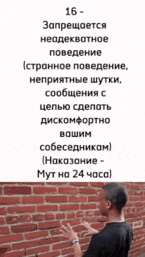 a man standing in front of a brick wall with a foreign language written on the top