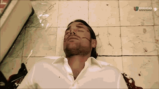 a man with blood on his face is laying on a tiled floor in front of a sign that says atnovelas