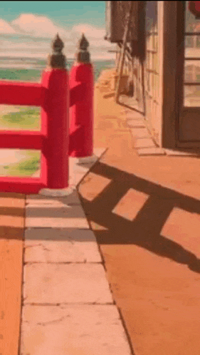 a red fence is sitting on the sidewalk next to a building .