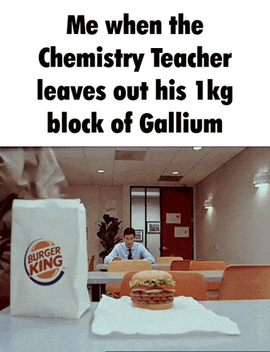 a man sits at a table in front of a bag of burger king