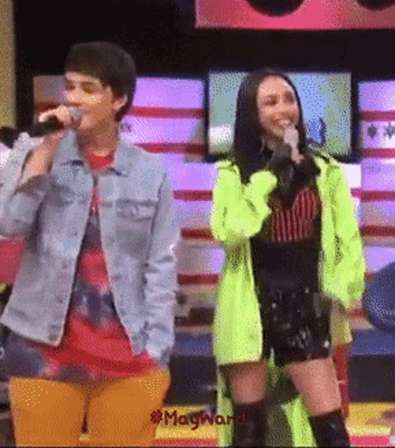 a man singing into a microphone next to a woman