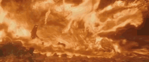 a person is standing in front of a large fireball .