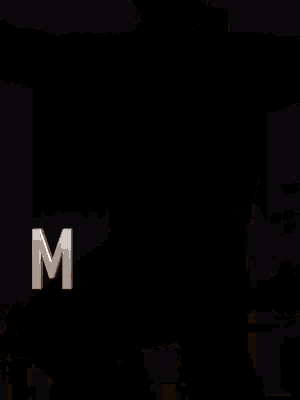 a man in a yellow jacket is kneeling on the ground with the letter r behind him