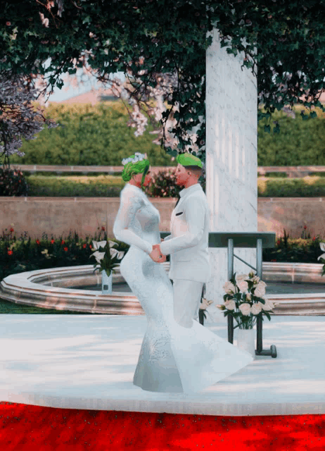 a bride and groom are dancing in front of a fountain in a garden
