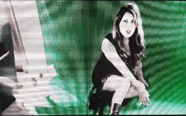 a woman in a black dress is sitting on a green background